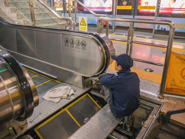 Changsha/China-18 October 2018:Unacquainted Chinese worker repairing escalator in Changsha Metro station.changsha is the capital and most populous city of Hunan